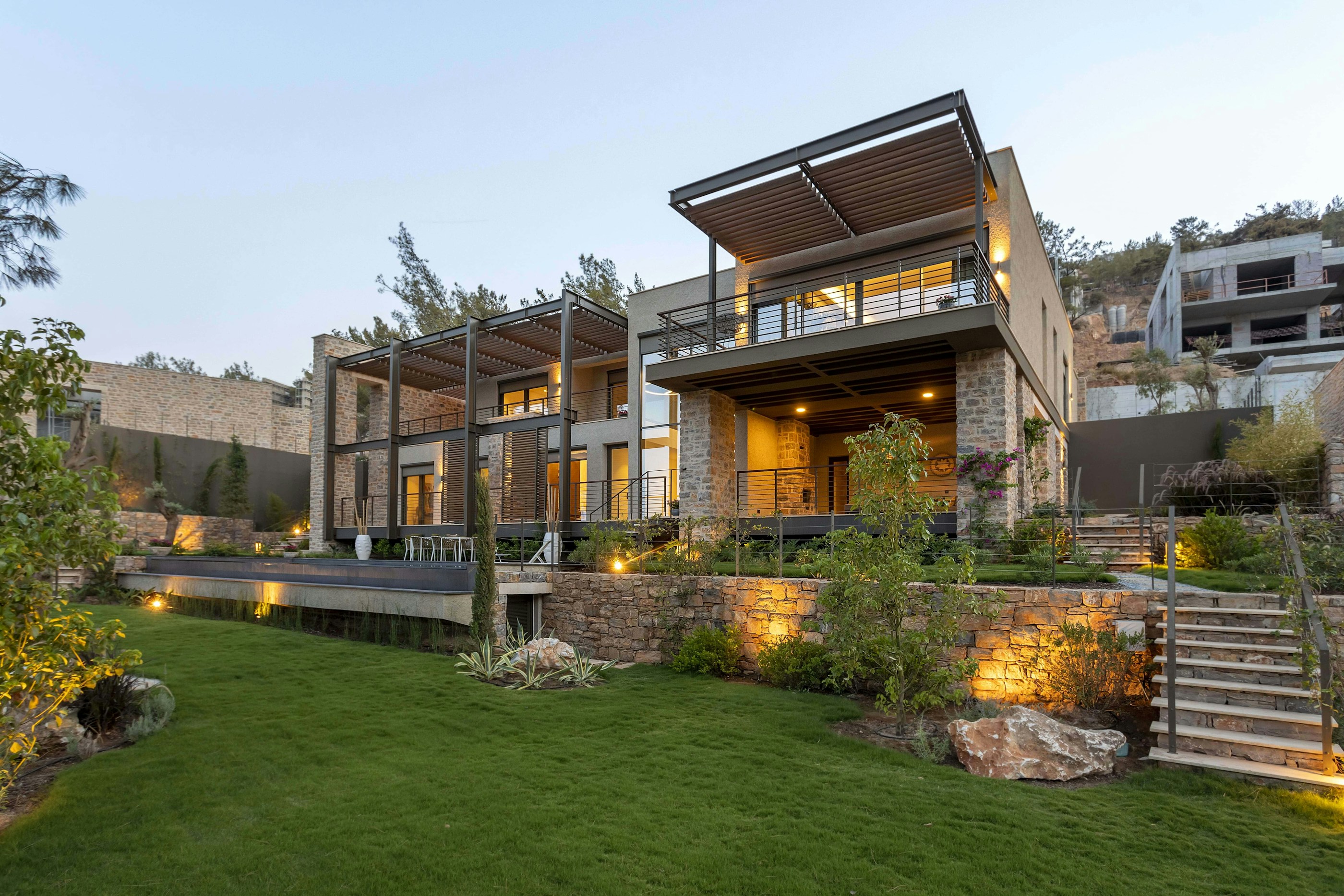 Zeitgenössisches privates Wohnhaus mit warmen Innenlichtern und ruhiger Gartenarchitektur
